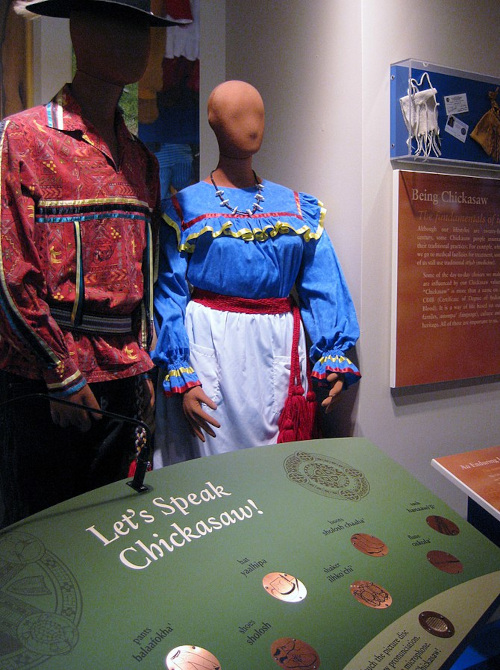 Chickasaw dress and language exhibit at Chickasaw Cultural Center in Sulphur, Oklahoma; image courtesy of Sheila Scarborough and Wikimedia Commons