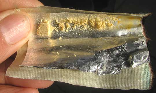 base of used ear candle showing powdery wax removed from ear