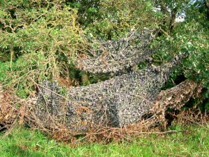 A hide with camouflage netting on the Bow Burn, Kerse Castle, East Ayrshire, Scotland; image courtesy of 'Rosser1954' and Wikimedia Commons